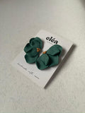 Green floral earrings on a 'Clea' branded card against a light background