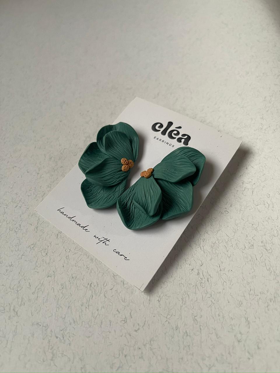 Green floral earrings on a 'Clea' branded card against a light background
